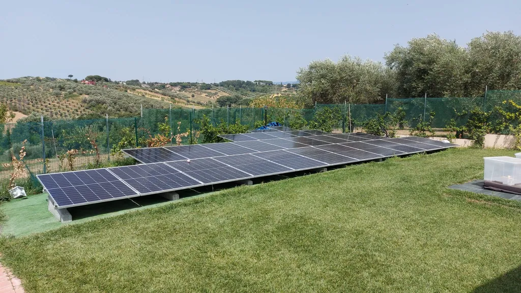 Impianto fotovoltaico con pannelli posati a terra in un’area verde